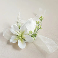 White floral corsage with green leaves on a beige background