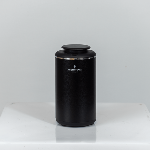Black cylindrical container with lid on a white background