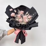 Hand holding the elegant Designer's Choice Nude Pink Preserved Rose Bouquet, a thoughtful and long-lasting flower gift for any special occasion.