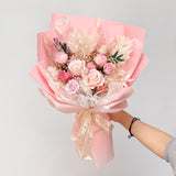 Person holding Aromatears' pink preserved rose bouquet demonstrating actual size and scale of this Vancouver florist's luxury everlasting arrangement