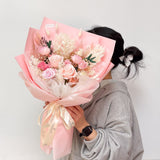 Woman holding Aromatears' pink preserved rose bouquet demonstrating actual size and scale of this Vancouver florist's luxury everlasting arrangement